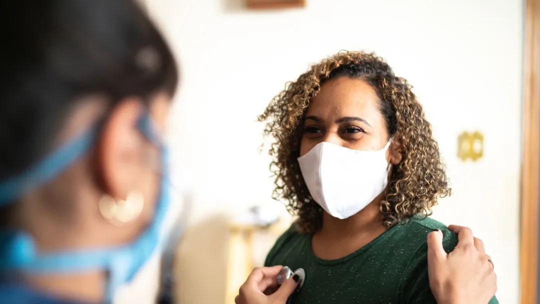 A Doctor Checks the Breathing of a Female Patient With a Stethoscope in an Office