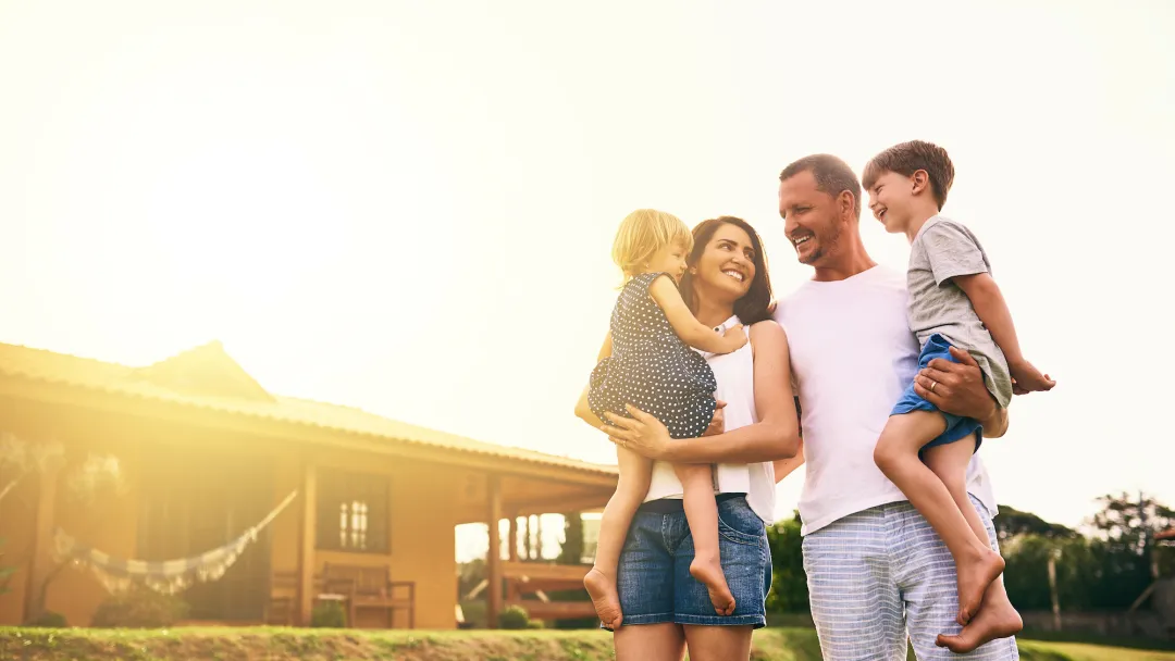 Mother and father walking with children in their front yard