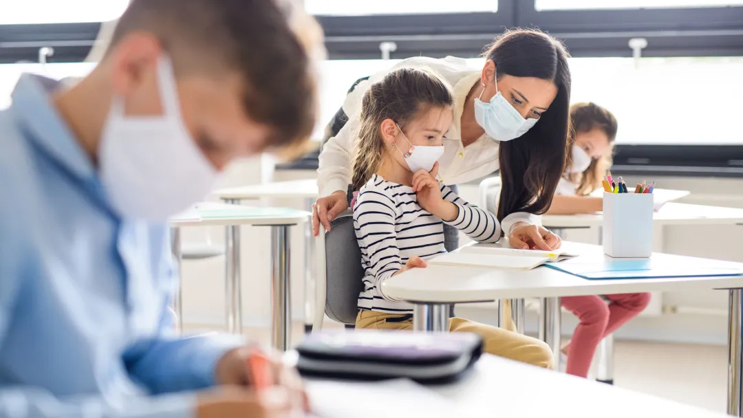 Teacher in classroom with students wearing masks