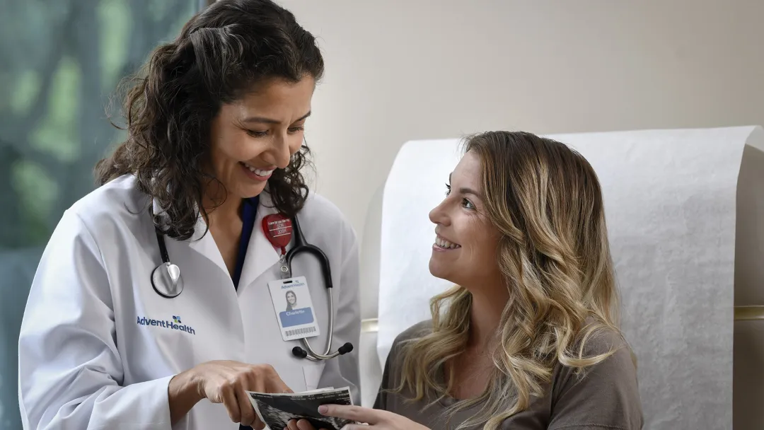 Young Woman talking to her doctor in a patient room.