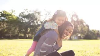 Daughter climbing on her favorite jungle-gym: her mother.