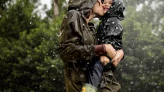 Mom and little boy playing in the rain.