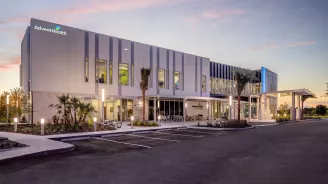 Exterior of AdventHealth Care Pavilion Central Pasco at night.