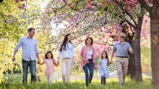 A family walking through a spring environment while holding hands