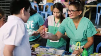 A nurse assisting a young boy from the Philippines