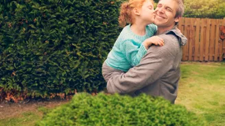 daughter hugging and kissing father outside