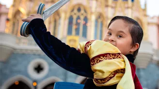 A boy dressed as a prince by Cinderella's castle at Magic Kingdom at Walt Disney World® Resort.