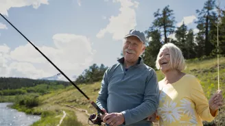 Older couple fishing together outdoors.