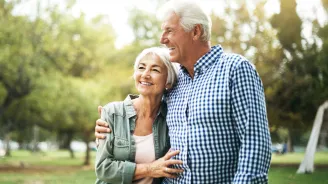 A Senior Couple Hugs in the Woods
