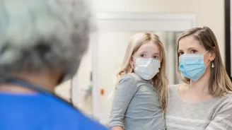 A mother and daughter wearing masks.