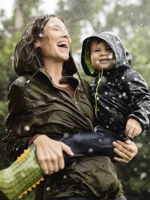 A mother and her young son play in the rain.