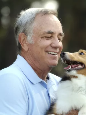 A Caucasian man plays with his pet Collie dog.