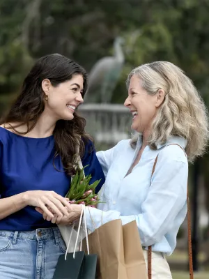 Two smiling women standing together outdoors.