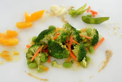 A dish comprised of broccoli, edamame, carrots, and other various ingredients