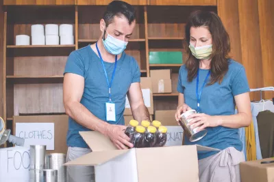 Two food drive volunteers wearing face masks.