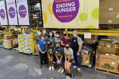 A group of volunteers in front of boxes of donated food