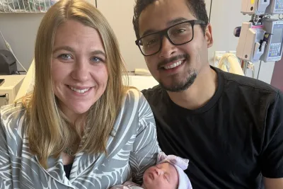 Baby Eliza with her mother and father in a hospital room.