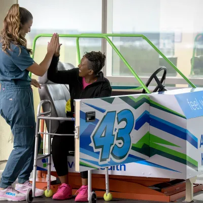 A female patient hi-fiving her healthcare provider