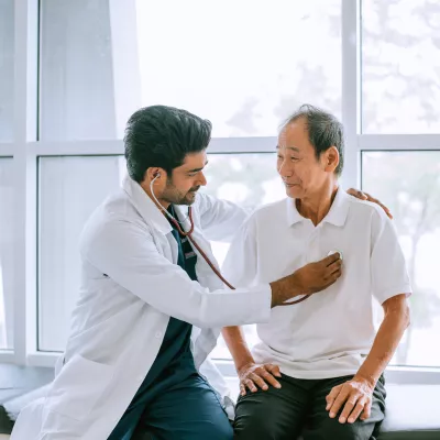 A Physician Listens to His Patients Heart with a Stethoscope 