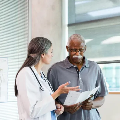 A Doctor Speaks to Her Patient in an Exam Room While Going Over His Treatment Plan.