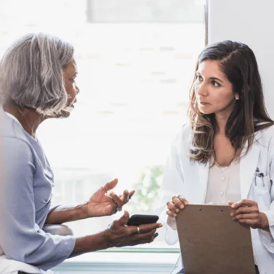 A Doctor and Patient Speak in an Exam Room