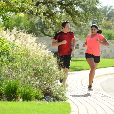 Smiling couple running outside on a sidewalk