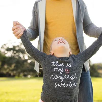 Daughter smiling looking up to father outside