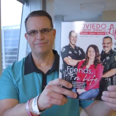 Officer Blayne holding a magazine covering his kidney transplant journey.