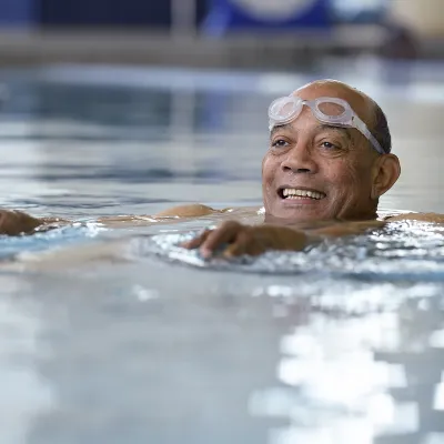 An African American man swims in an indoor pool for exercise