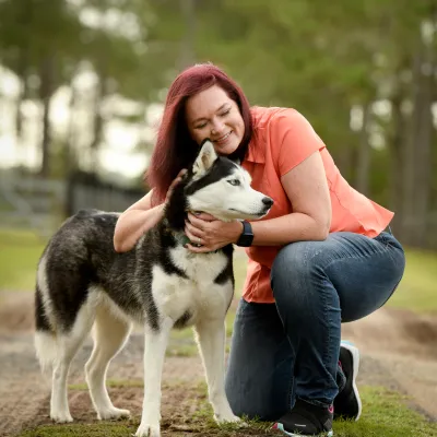 Woman petting her dog while outdoors.