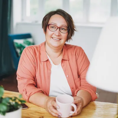A smiling woman sitting at a desk.