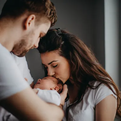 A young couple holding their newborn baby