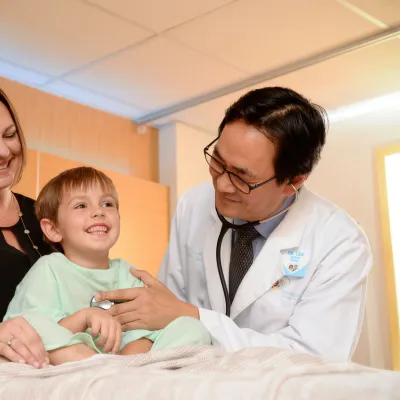 Photo of Doctor checking on pediatric patient and mom