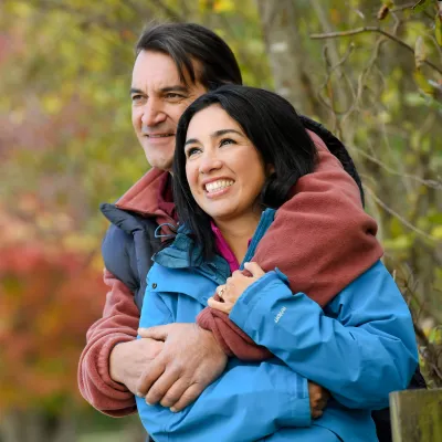 Couple embracing in the woods.