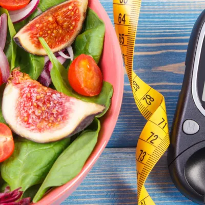 A picture of a salad, measuring tape, and a sugar monitor
