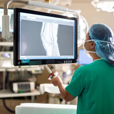 doctor in scrubs examining an x-ray in a surgical room