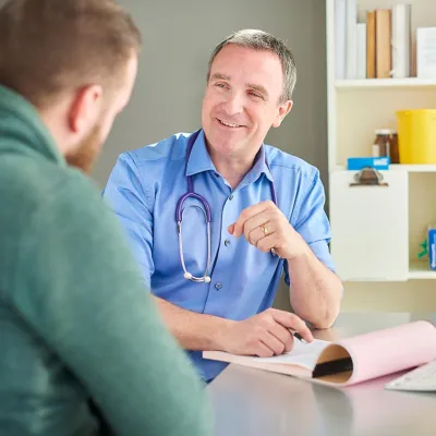 Doctor casually talking with patient while taking notes