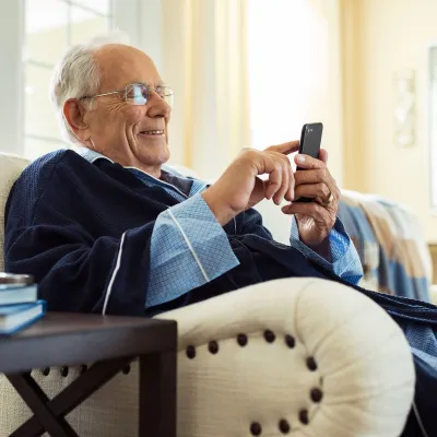 An elderly man relaxing at home seating on his couch.