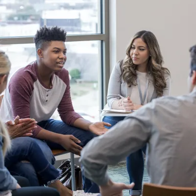 A diverse group of people sitting in chairs talking