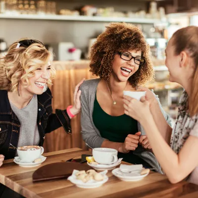 Women smiling and laughing together at a restaurant