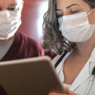 A doctor showing her patient something on her business tablet