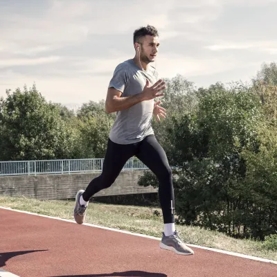 A man running outdoors on a track.