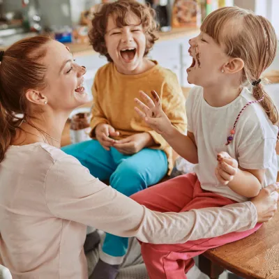 A mom laughs her way through a messy lunch with her kids.