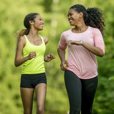 A mother running with her teenage daughter.