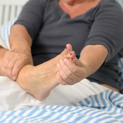 A senior woman massages her foot