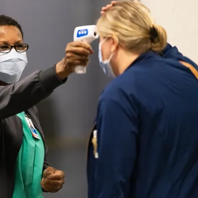 A woman has her temperature checked before a visit.