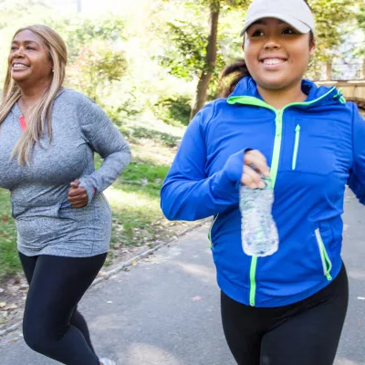 Two women running outside in the fall.