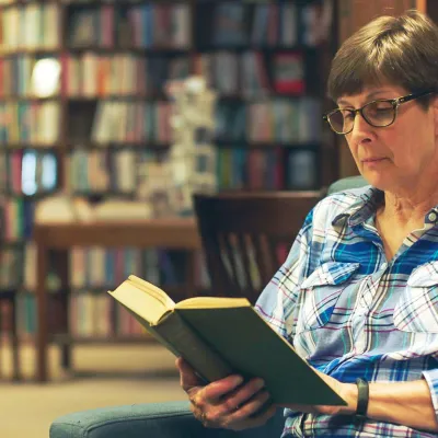 Woman reading book in library
