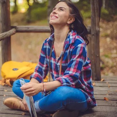 A woman takes a deep breath while sitting outside.