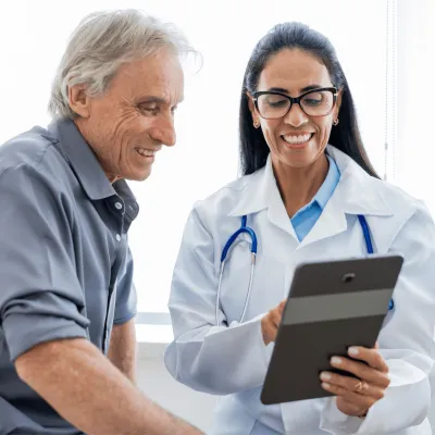 An older man speaking to a female physician.